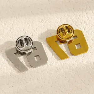 Dettaglio della chiusura a farfalla sulle spille numero 67 in acciaio inox oro e argento