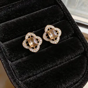 Detailed close-up view of hollow flower stud earrings with sparkling champagne crystals