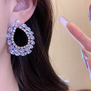 Gros plan détaillé d'élégantes boucles d'oreilles créoles en zircone en forme de goutte