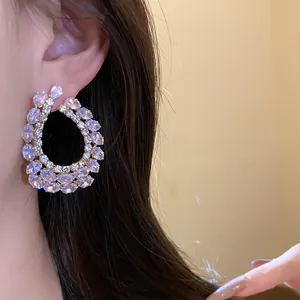 Détail rapproché de grandes boucles d'oreilles en forme de goutte serties de zircons