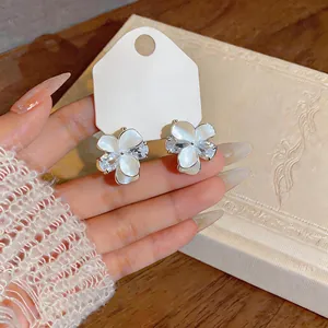 Elegant flower stud earrings featuring white petals and shimmering cubic zirconia crystals