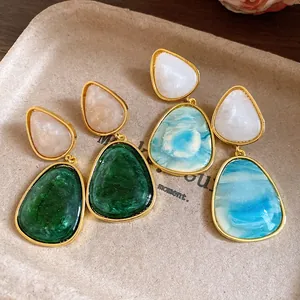 Detail view of vintage resin drop earrings featuring marble and emerald green patterns