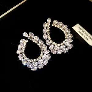 Détail de boucles d'oreilles goutte de luxe avec zircones cubiques étincelantes