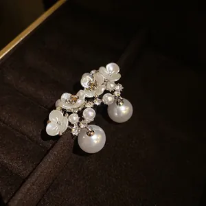 Detailed view of elegant French vintage floral pearl earrings in a luxury jewelry box