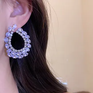 Vue détaillée de boucles d'oreilles goutte d'eau en zircone portées par un mannequin.