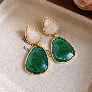 Macro view of vintage resin drop earrings featuring elegant green marble texture