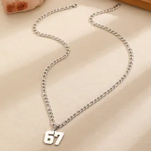 Primo piano di una collana in acciaio inossidabile con ciondolo numero 67 e catena Figaro