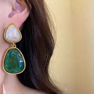 Close-up detail of vintage resin triangle pendant earrings with green marble effect.