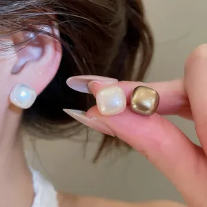 Macro view of geometric square pearl earrings showing elegant luster and smooth finish