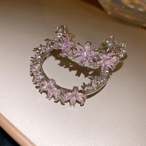 Detailed close-up showing pink zircon floral patterns on these C-shaped earrings
