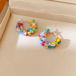 Vibrant rainbow beaded hoop earrings with frosted finish in a beige jewelry box
