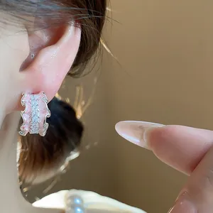 Elegante C-förmige Ohrstecker mit rosa Emaille-Rüschen und Zirkonia in der Detailansicht.