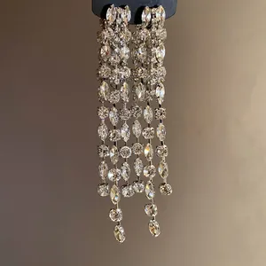 Detailed view of sparkly silver long tassel earrings with clear geometric rhinestones