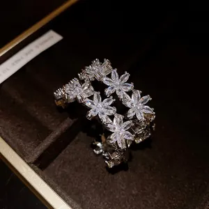 Close-up of sparkling zircon flower C-shaped earrings in a dark luxury gift box