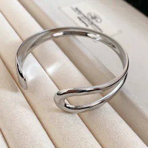 Detail showing the irregular open loop design of the silver metal cuff bracelet