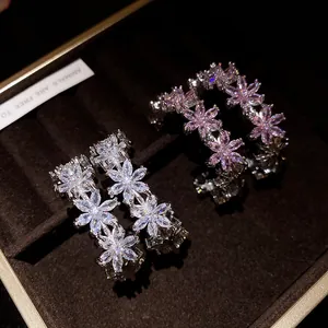 Detailed view of zircon flower C-shaped earrings with sparkling pink and clear stones.