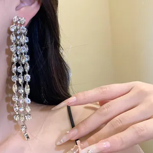 Close-up of sparkling long crystal tassel earrings with dramatic silver drop design