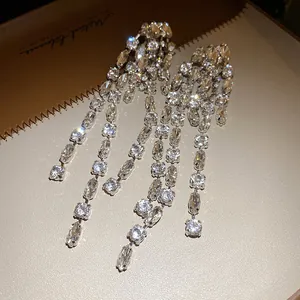 Detailed close-up of sparkling geometric long tassel earrings with silver needle base