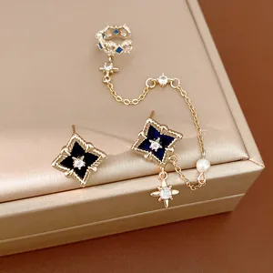 Detailed view of elegant gold zircon star earrings set with chain ear cuff and pearl