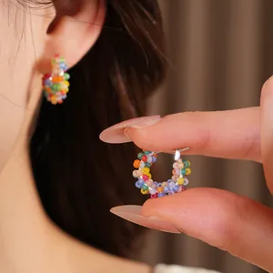 Close-up of colorful beaded hoop earrings showing detailed handmade craftsmanship