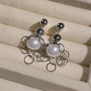 Chic French retro pearl earrings featuring dangling silver rings in jewelry tray