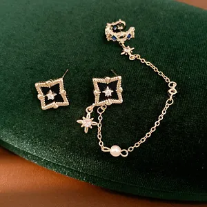 Detailed macro shot of vintage-style star rhombus earrings and pearl chain ear cuff set