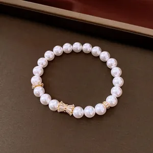 Elegante bracciale elastico con perle di zirconi e un accento a farfalla dorata di lusso