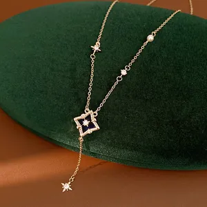Close-up of elegant gold rhombus star necklace with blue enamel and sparkling zircon
