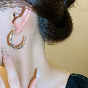 Detailed view of 18k real gold plated C-shaped earrings with shimmering zircon stones