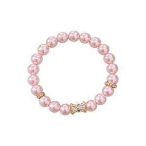 Elegante bracciale elastico con perle rosa, ciondolo a fiocco in zirconia e distanziatori