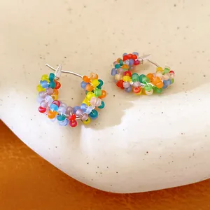 Macro detail of colorful beaded hoop earrings with vibrant matte rainbow beads