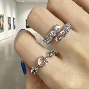 Primo piano di anelli aperti in zircone e resina indossati in una galleria d'arte