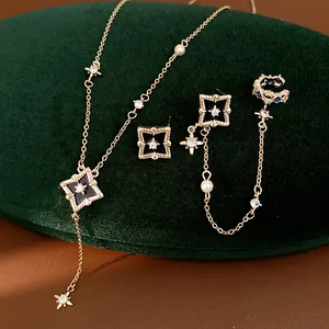 Close-up of elegant gold zircon jewelry set with rhombus star pendant and matching earrings