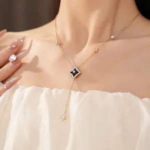 Detail of an elegant Y-shaped necklace with a black rhombus pendant and star motif zircon.