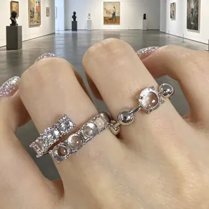Dettaglio ravvicinato di anelli aperti in zircone e resina con design in argento
