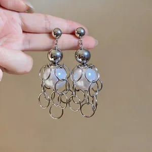Close-up of vintage French style earrings with silver ring tassels and large pearls