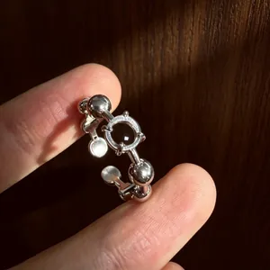 Primo piano dettagliato di un anello in argento con sfere e centro in resina nera