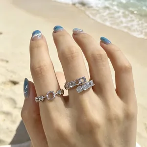 Vista dettagliata di eleganti anelli in zircone e resina indossati sulla spiaggia