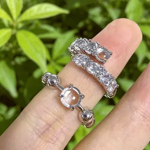 Dettaglio ravvicinato di anelli aperti color argento con zirconi ed elemento in resina