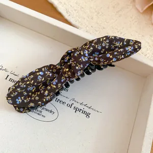 Close-up view of the floral bow banana hair clip with an elegant spring flower pattern