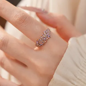 Detailed view of an elegant rose gold ring featuring a cluster of purple zircons on a finger
