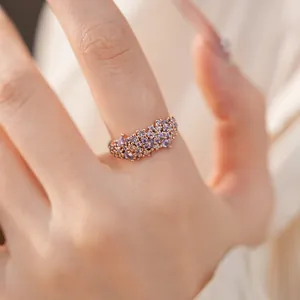 Close-up of elegant rose gold ring decorated with purple and clear cubic zirconia