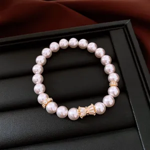 Primo piano di un bracciale di perle di lusso con ciondolo a fiocco in zircone dorato.