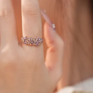 Exquisite close-up of a rose gold ring with sparkling purple cubic zirconia clusters