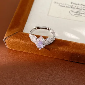 Close-up of a vintage silver ring featuring a pink oval zircon center and pave set wings