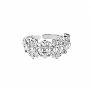 Elegant silver hollow adjustable ring with zircon stones and pearls in minimalist style.