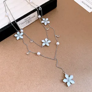 Dettaglio ravvicinato dei fiori smaltati e delle perle di questa bella collana a Y