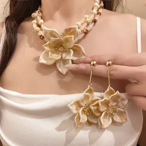 Detalle de conjunto de collar de cuentas multicapa y pendientes de flores de estilo étnico