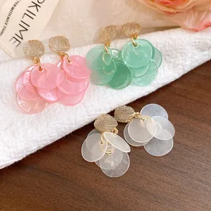Detail view of Korean style cat-eye stone petal tassel earrings in pink, green, and white