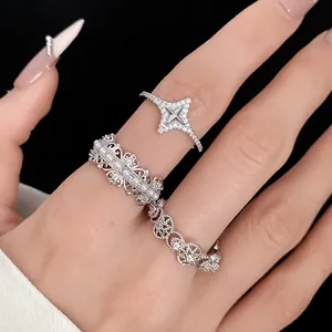 Close-up detail of silver-tone hollow rings set with sparkling zircon and pearls on hand